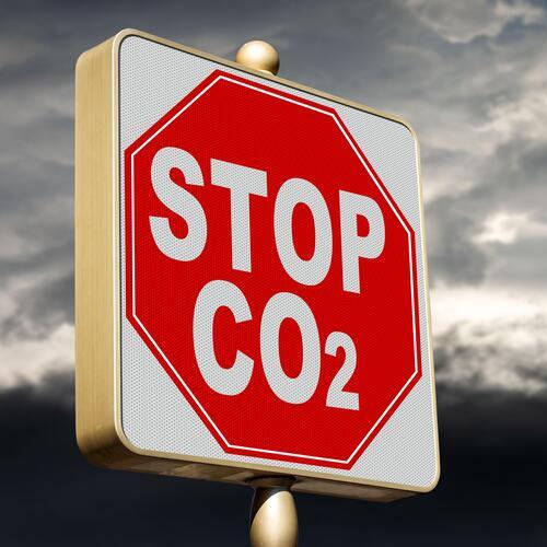 Closeup of a modern Stop road sign of CO2 (carbon dioxide), with a sky with pollution on background. Reduce greenhouse gas emission for climate change