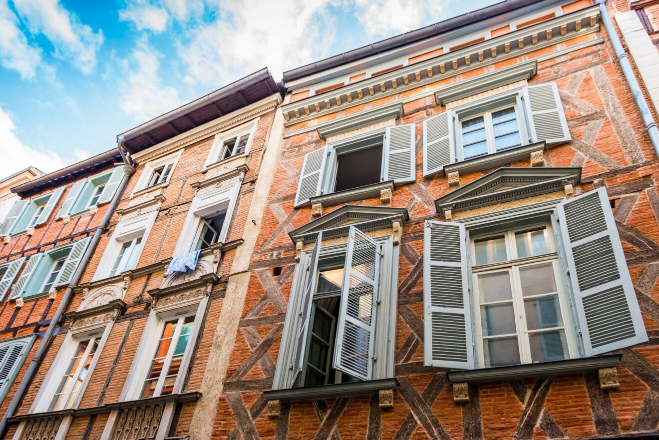 Facade of typical houses in an old street in the city center of Toulouse, in Occitanie, France